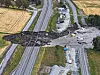 Oversiktsbilde av skred som har gått over E6 ved Levanger, med skadede veier og en bil i vannet.