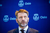 Eirik Lae Solberg taler foran en blå bakvegg med Oslo-logoer.
