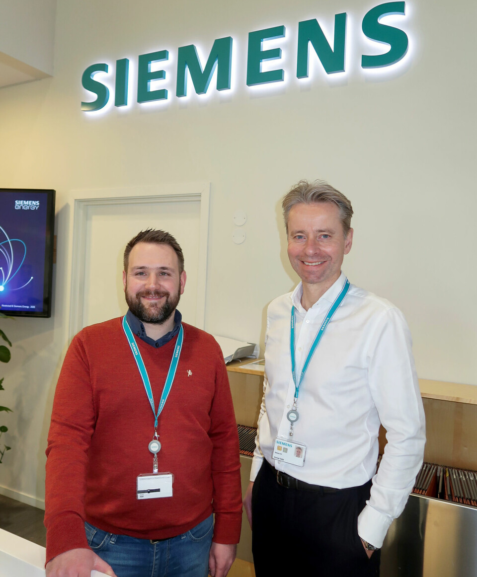 Tor Erik Sørensen og Gunnar Eidal foran en vegg med Siemens-logo