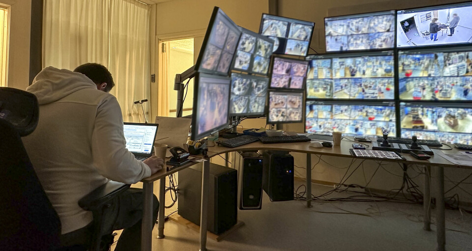 Trond Thoresen sitter ved en PC-skjerm inne på et rom med masse overvåkingsskjermer