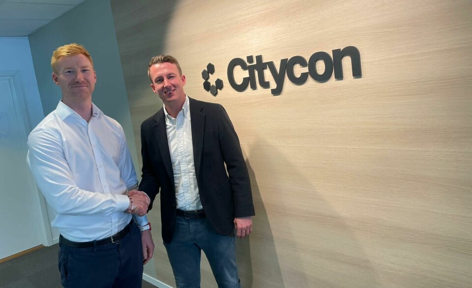 Håkon Tuv Dalland og Henrik Andersen tar hverandre i hånda foran et Citycon-skilt